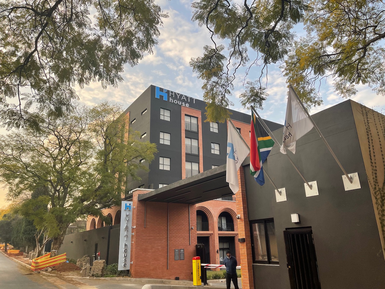 a building with flags and a man standing in front of it