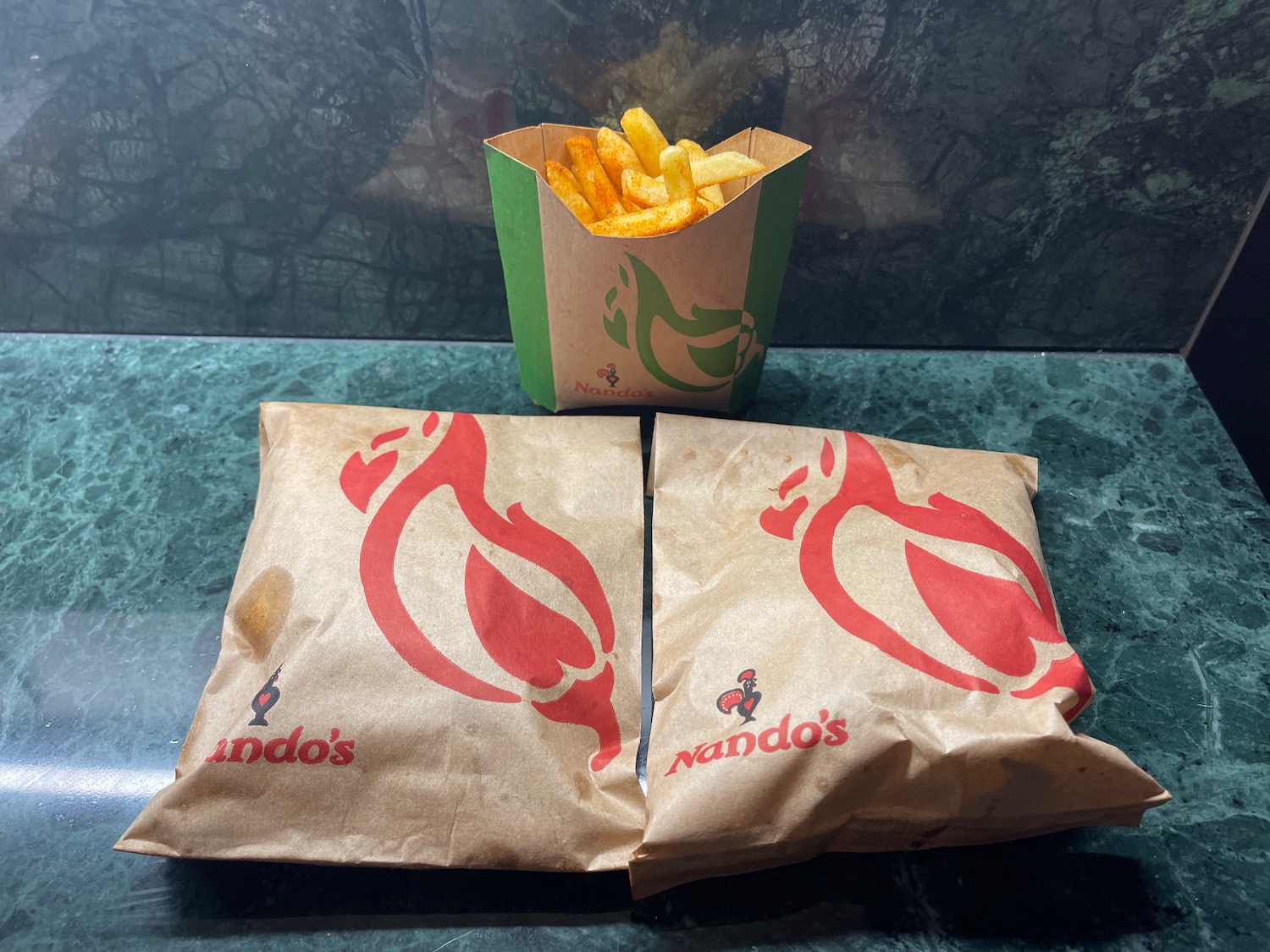 a paper bag with french fries and a container of fries