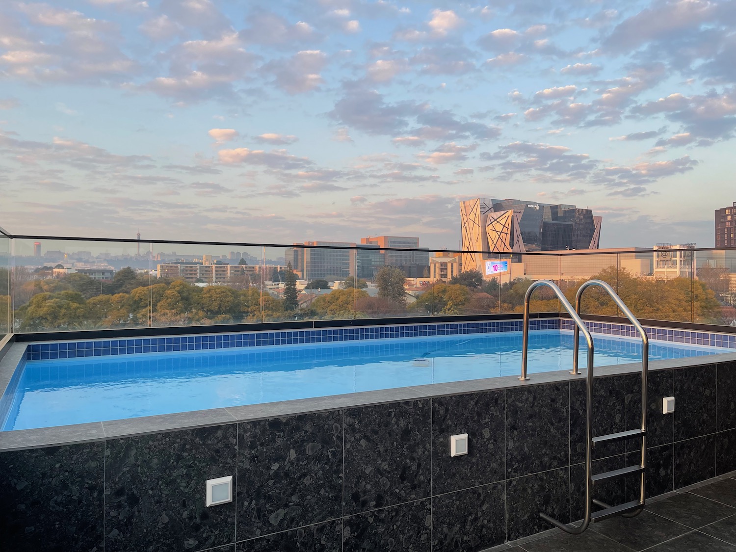 a pool with a railing overlooking a city