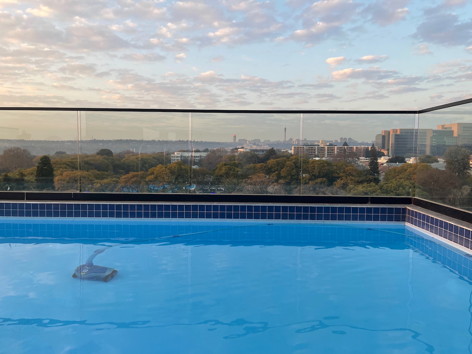 a pool with a view of a city and trees