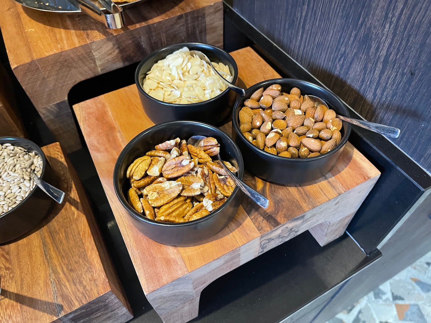 bowls of nuts and seeds on a wood cutting board