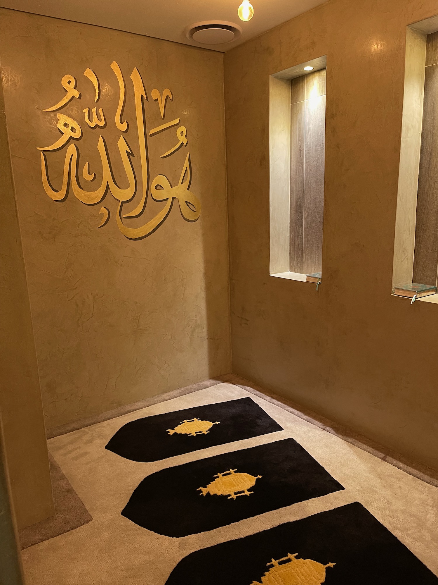 a room with a black rug and gold text on the wall