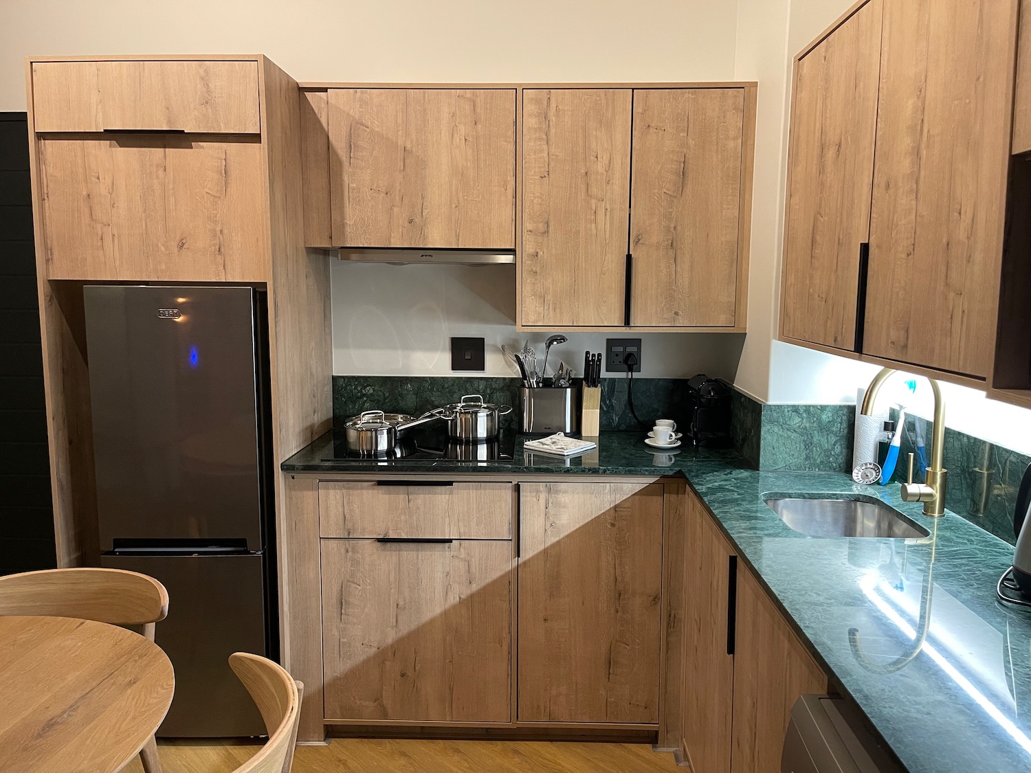 a kitchen with wooden cabinets and a black countertop