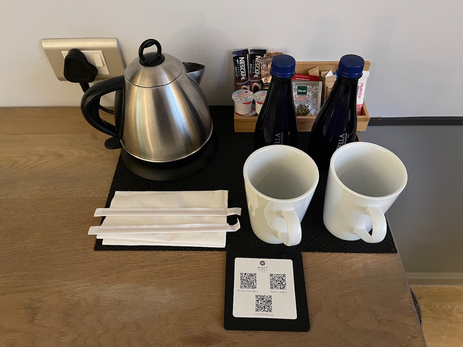 a coffee pot and two cups on a table