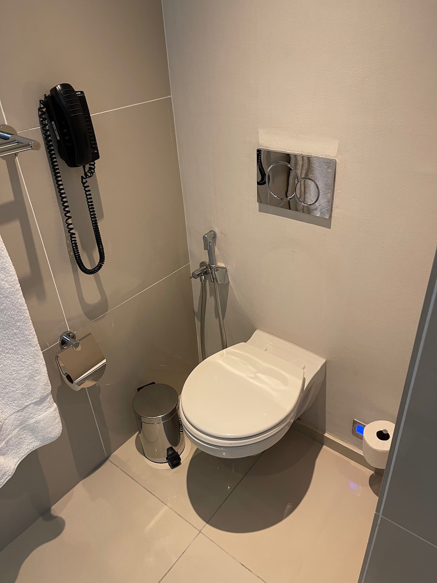 a bathroom with a phone and toilet