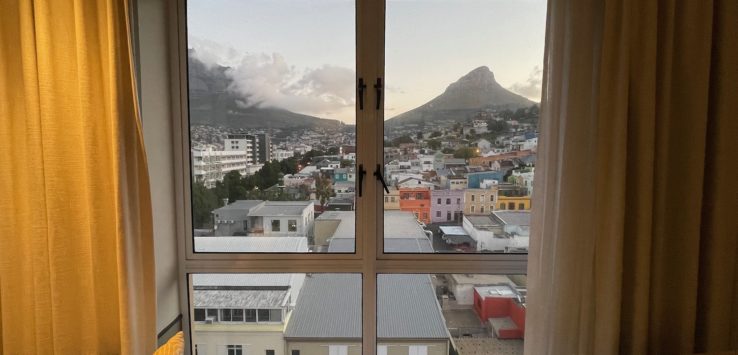a window with a view of a city and mountains
