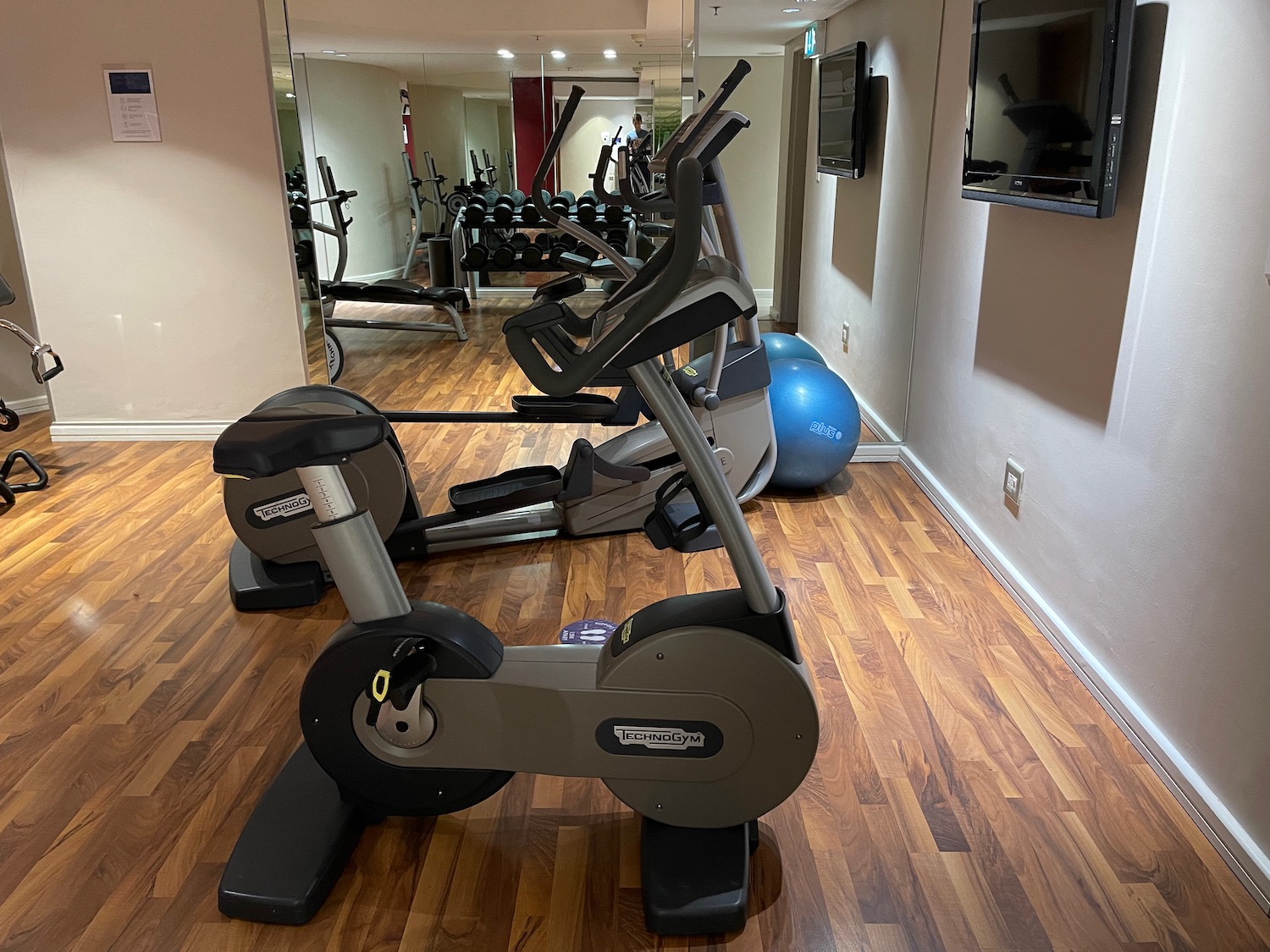 a room with exercise bikes and a mirror on the wall
