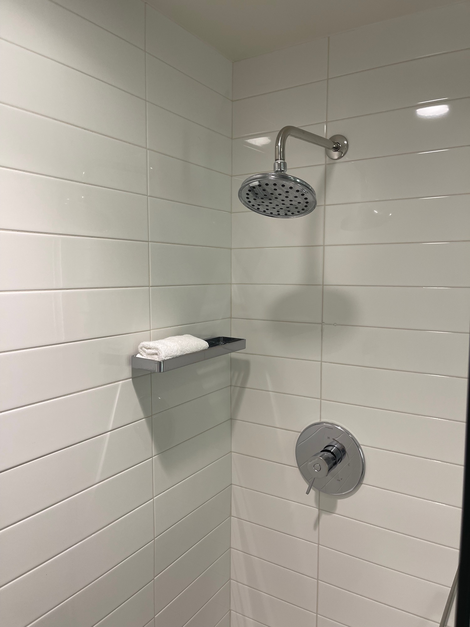 a shower head and a towel on a shelf