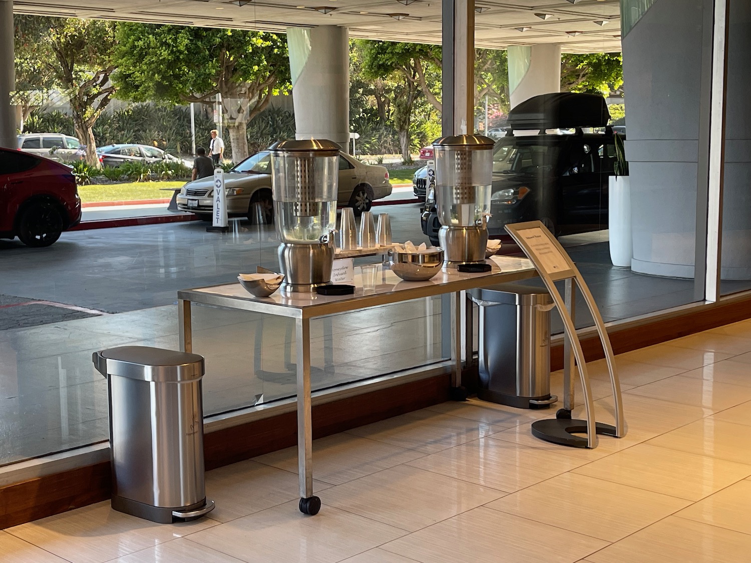 a table with a drink dispenser and trash can