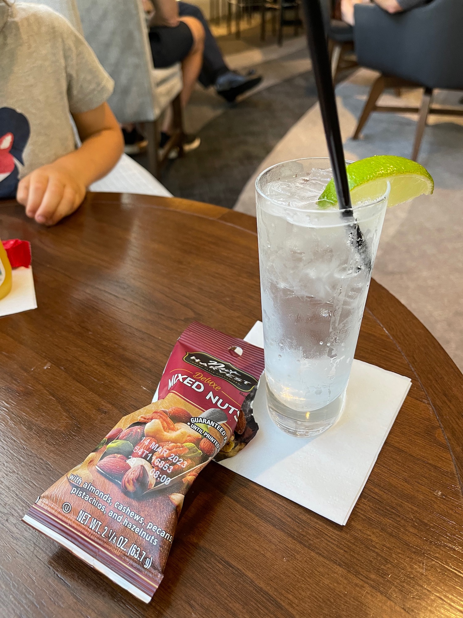 a glass of water with a straw and a lime slice on a table