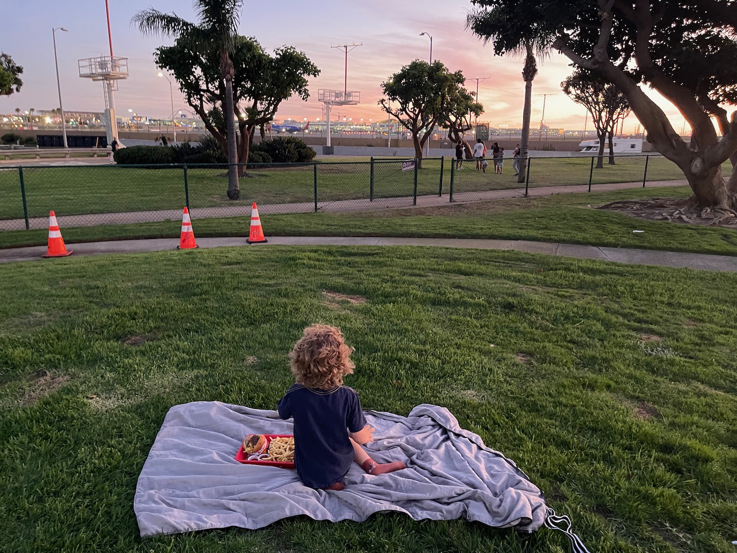 a child sitting on a blanket in a park