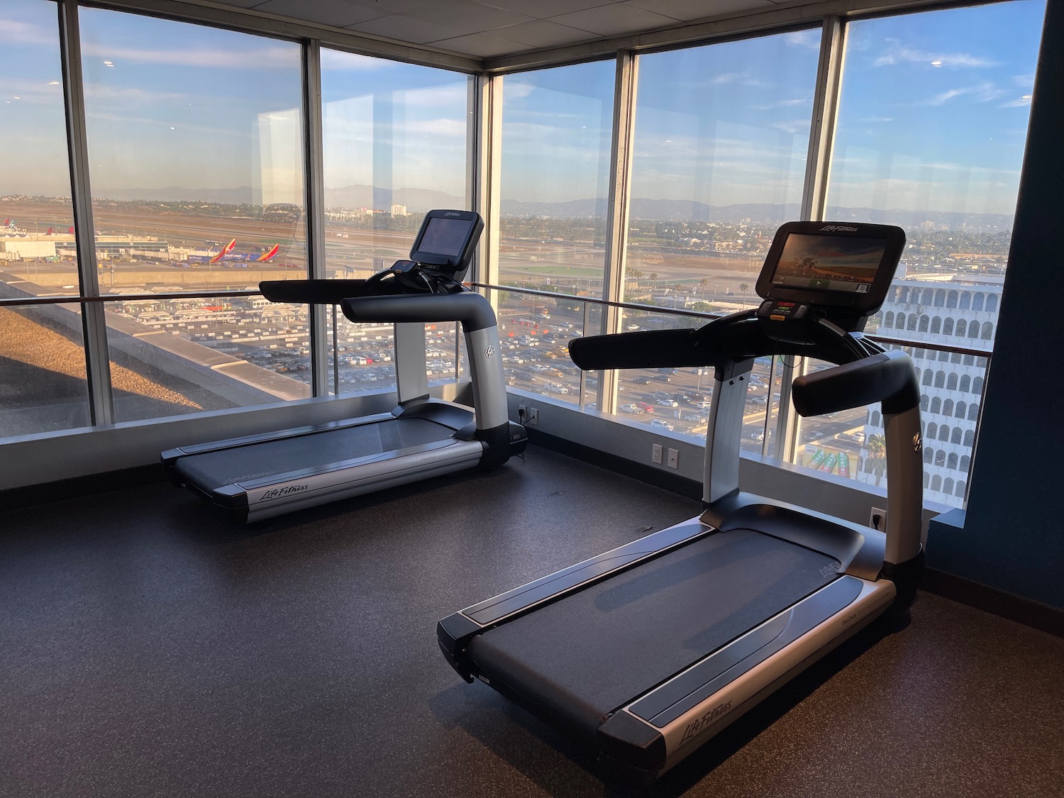 a room with treadmills and a view of a city