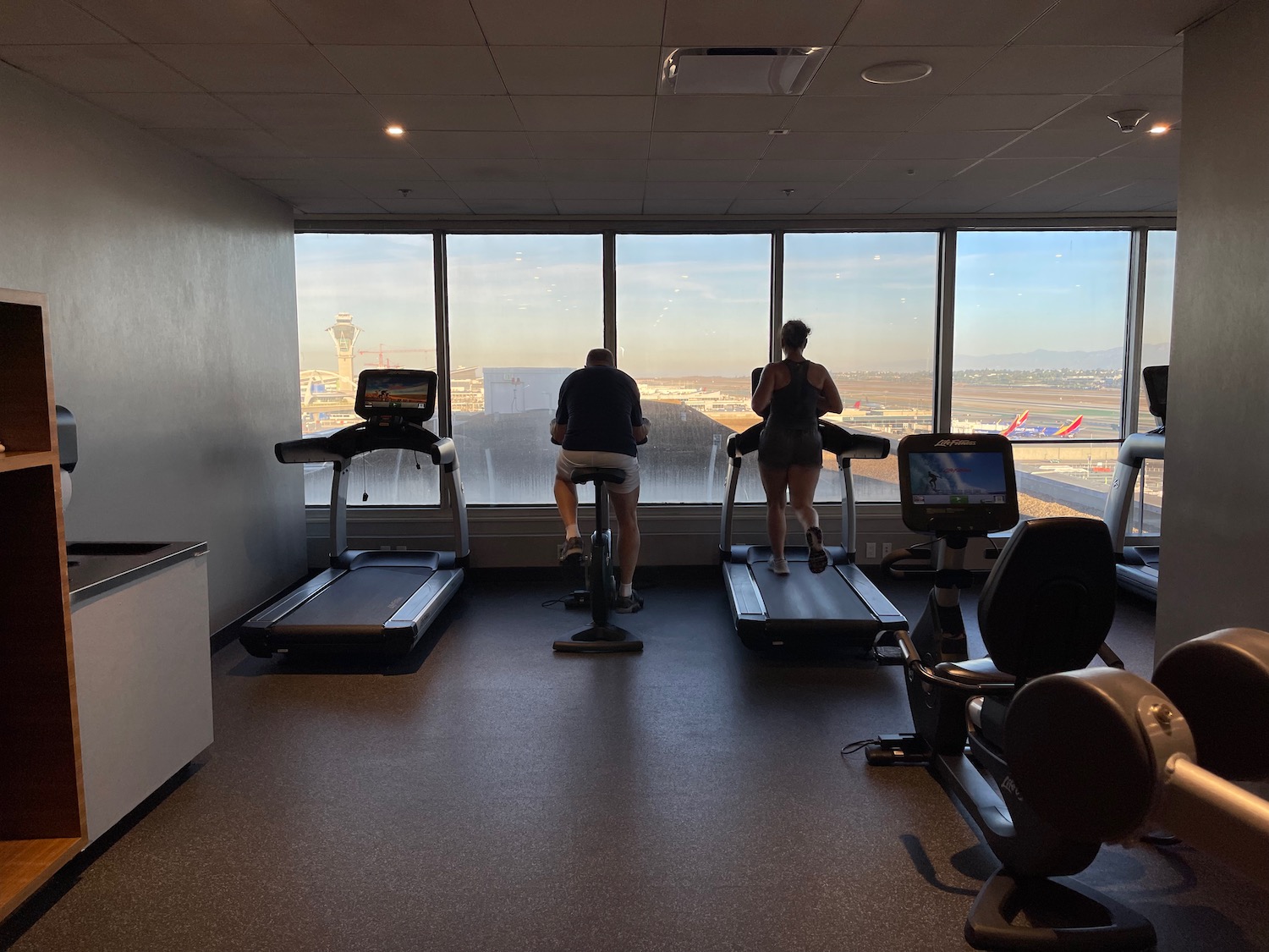 people in a gym with a window overlooking a city