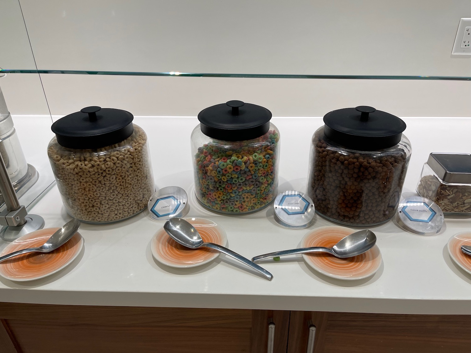 a group of glass containers with black lids and a black lid on a white surface