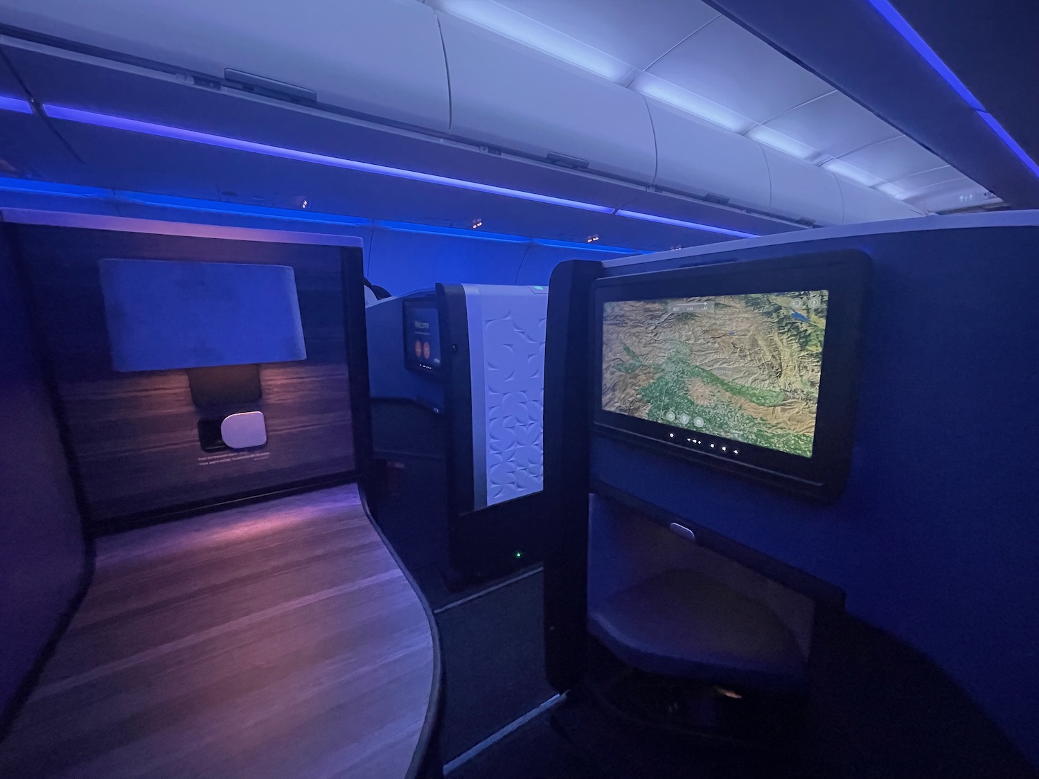 a desk and computer screens in an airplane