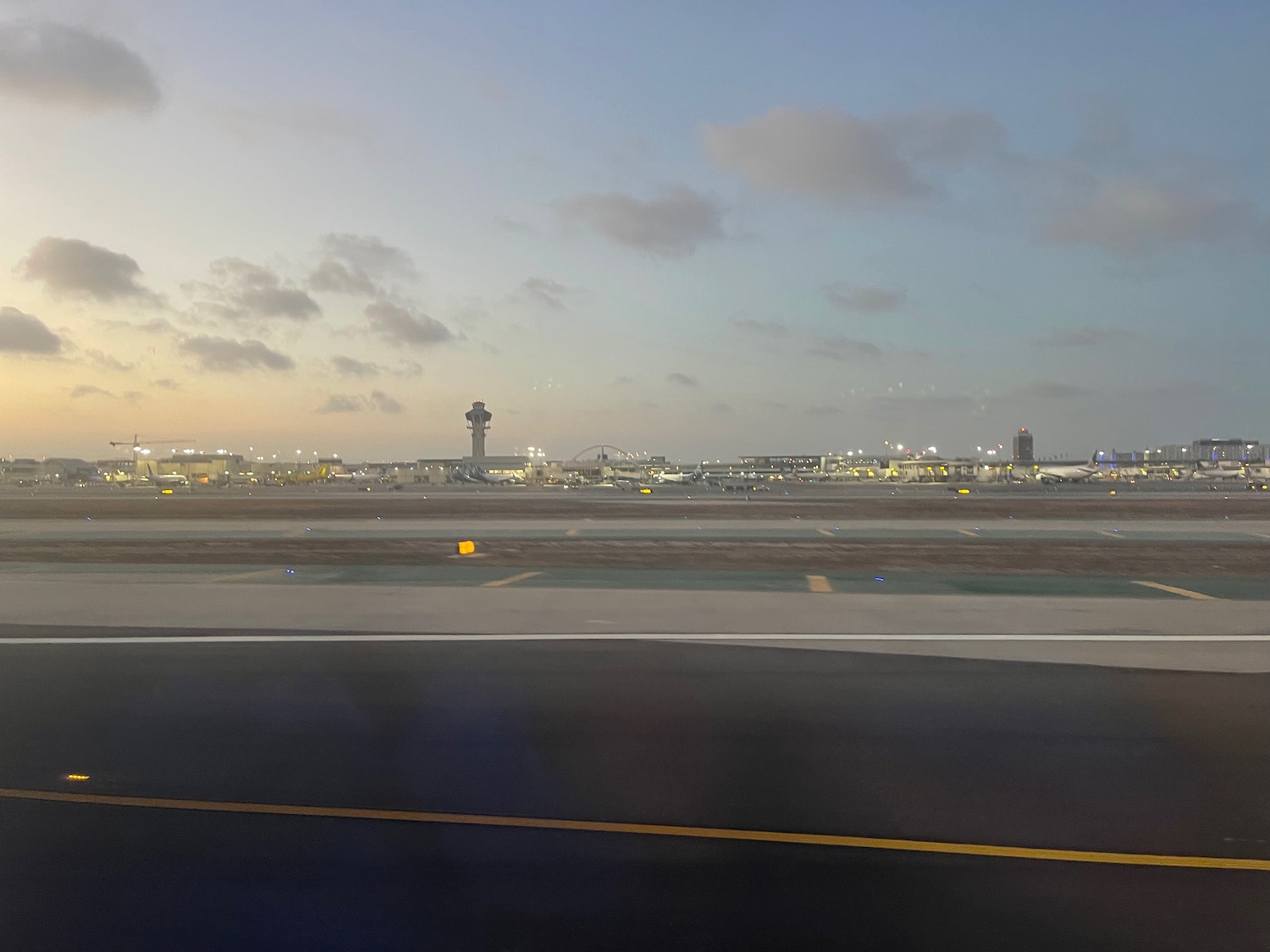 an airport runway with lights and a tower