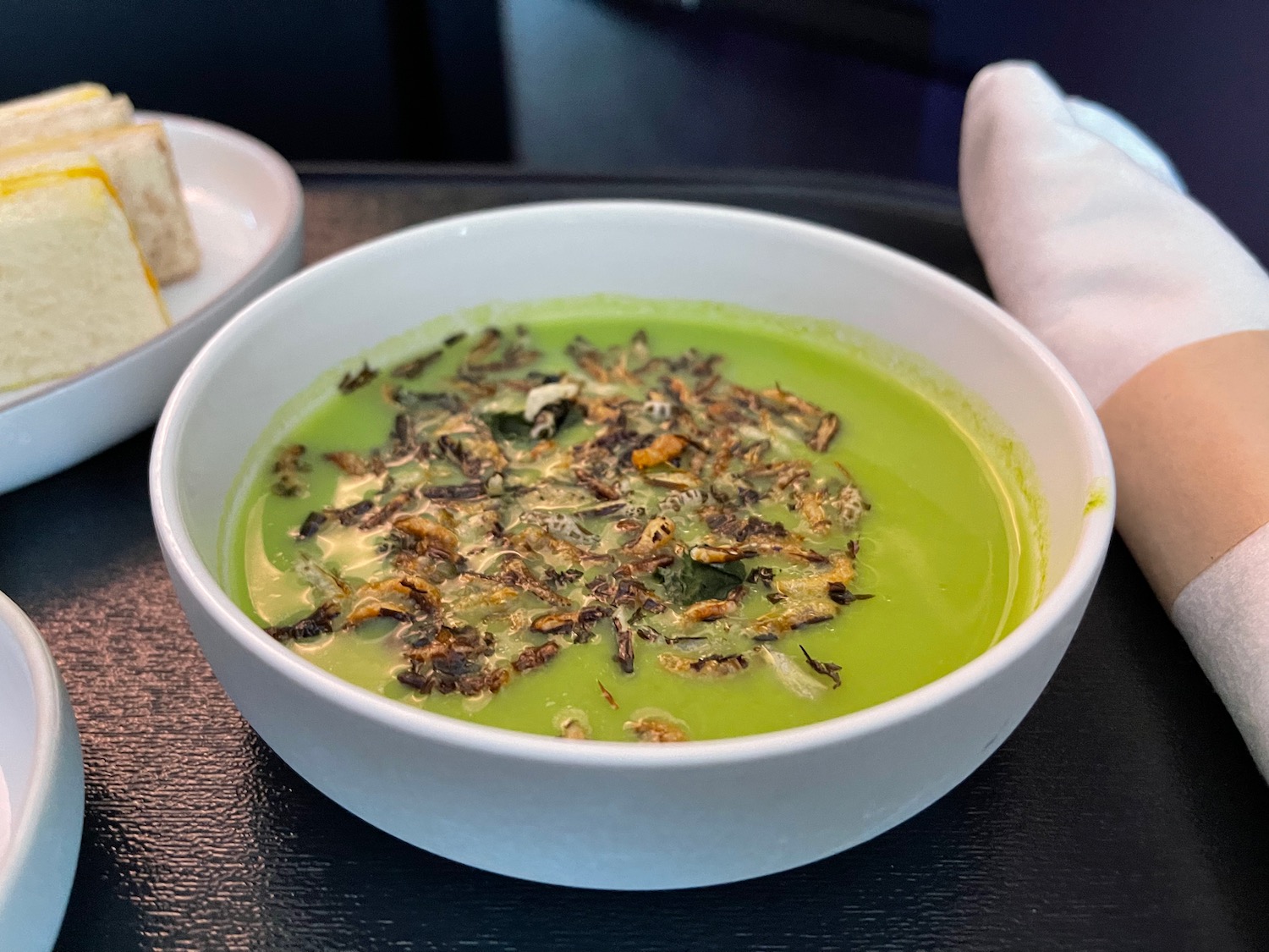 a bowl of green soup with food in it