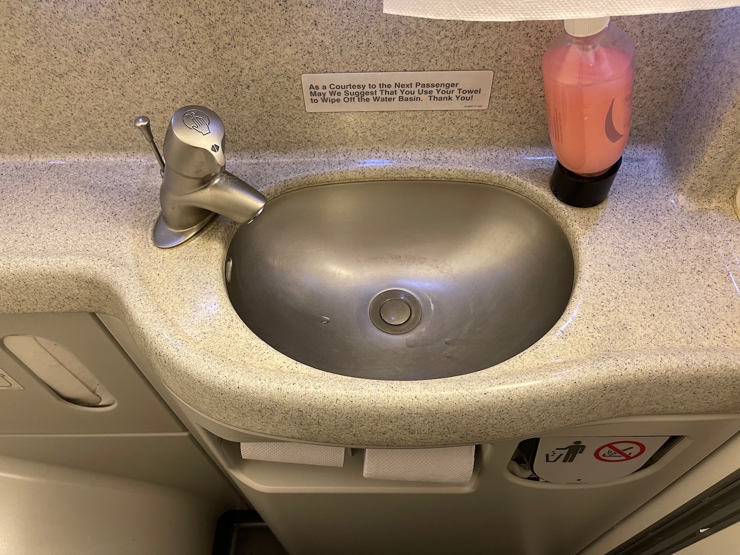 a sink with a soap bottle and a bottle of liquid