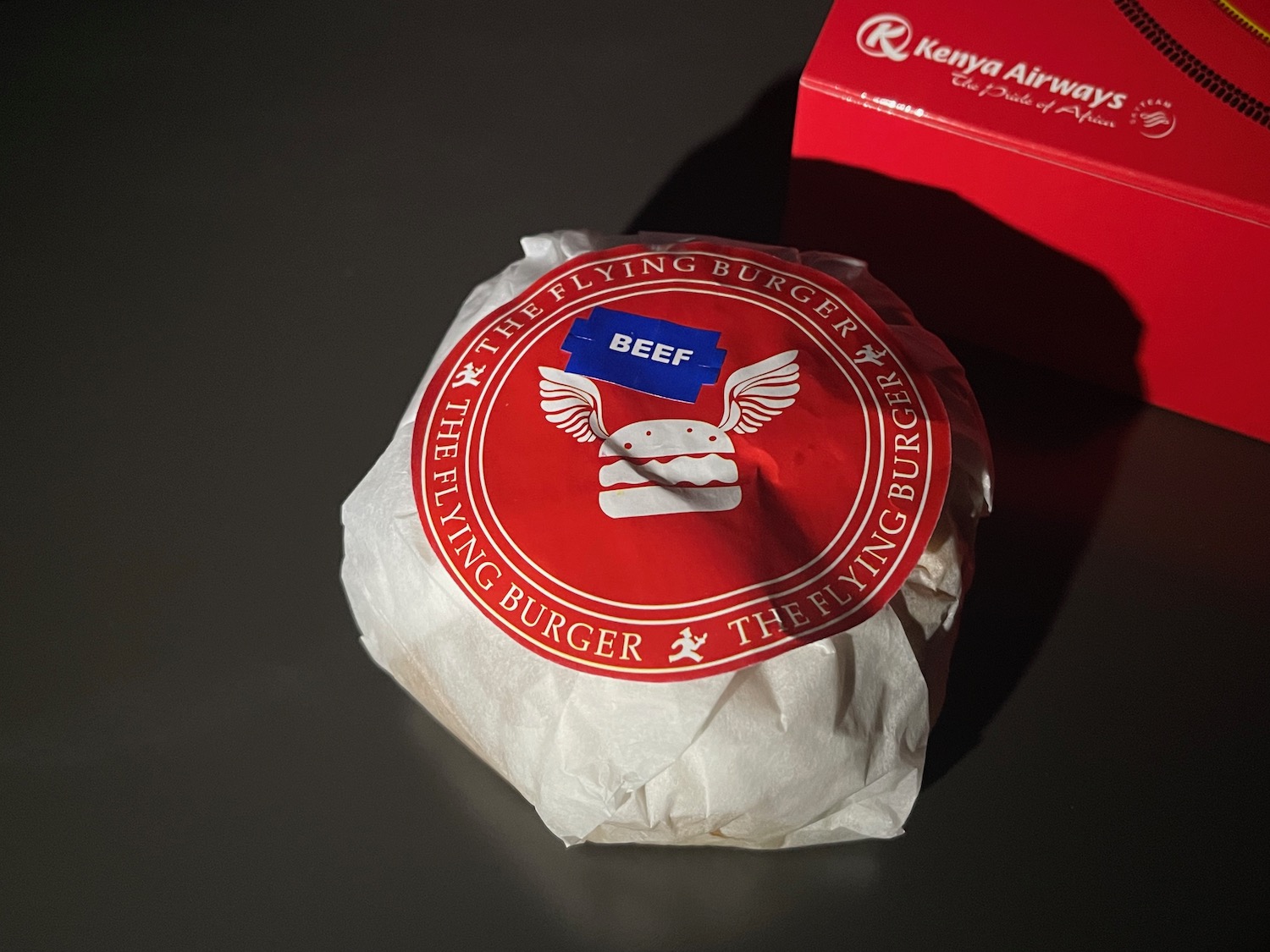 a burger wrapped in paper and a red box