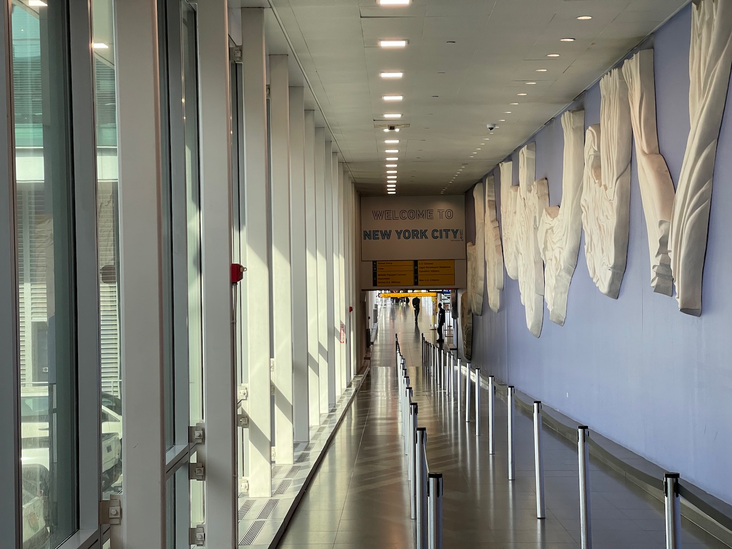 a hallway with large windows and a sign