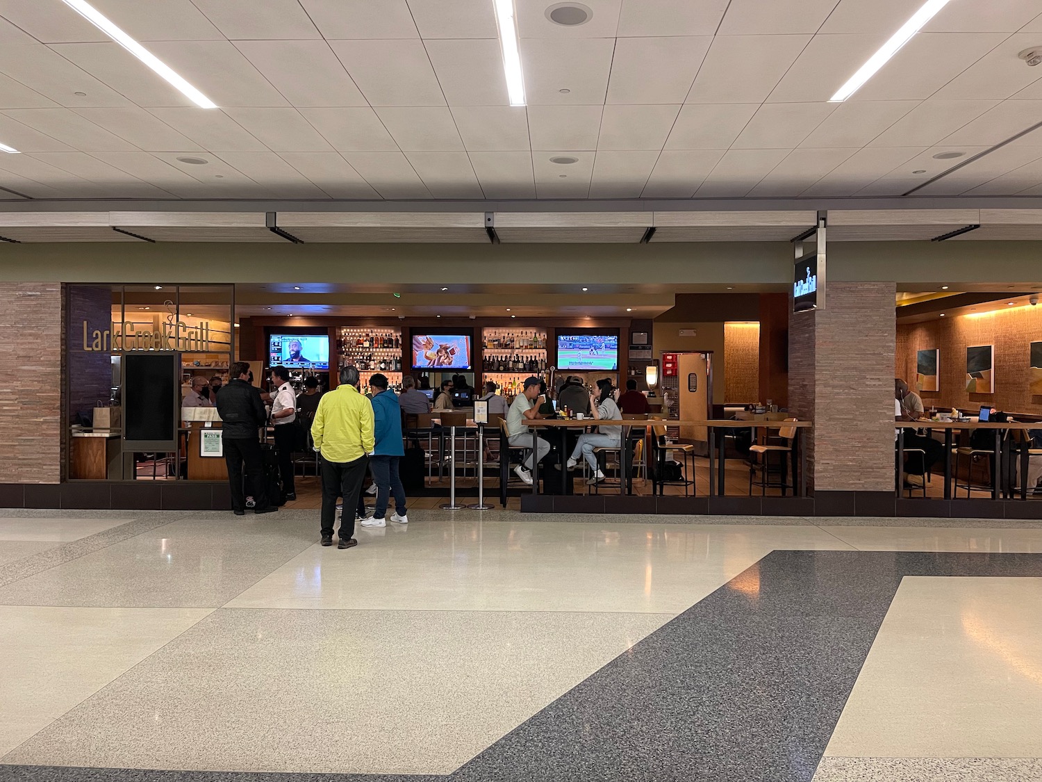 people standing in a room with people standing around a bar