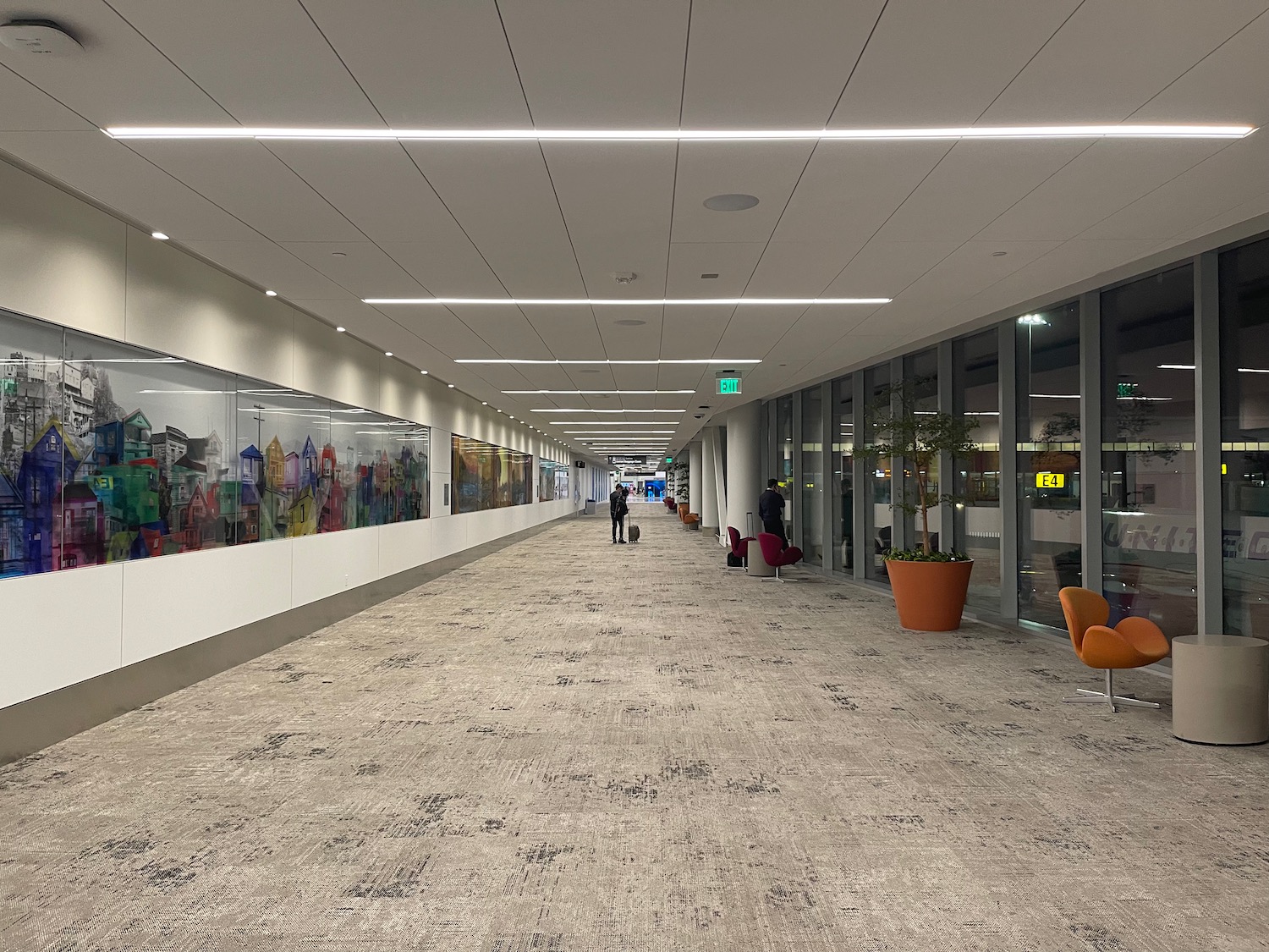 a hallway with a group of people standing in front of a wall