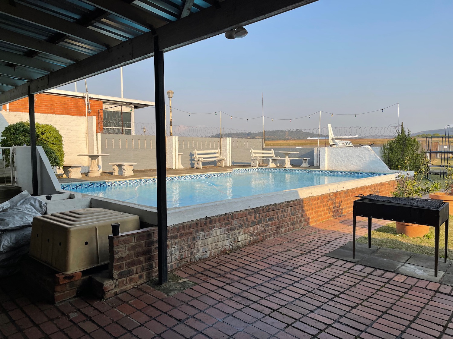 a pool with a grill and a grill on the patio