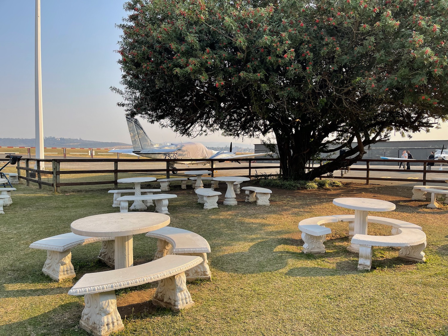 a picnic area with benches and tables in the grass