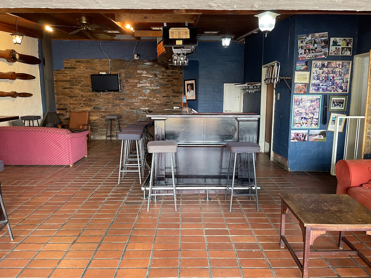 a bar with stools and a tv