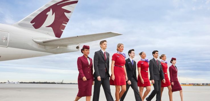 a group of people walking in front of an airplane