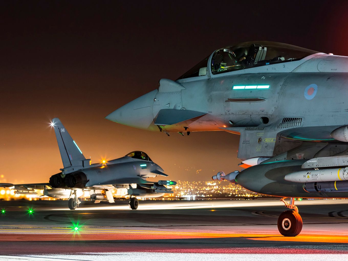 a jet planes on a runway at night