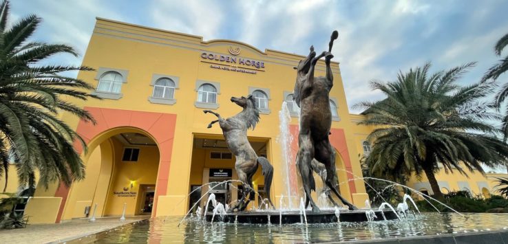 a statue of horses in a fountain in front of a building