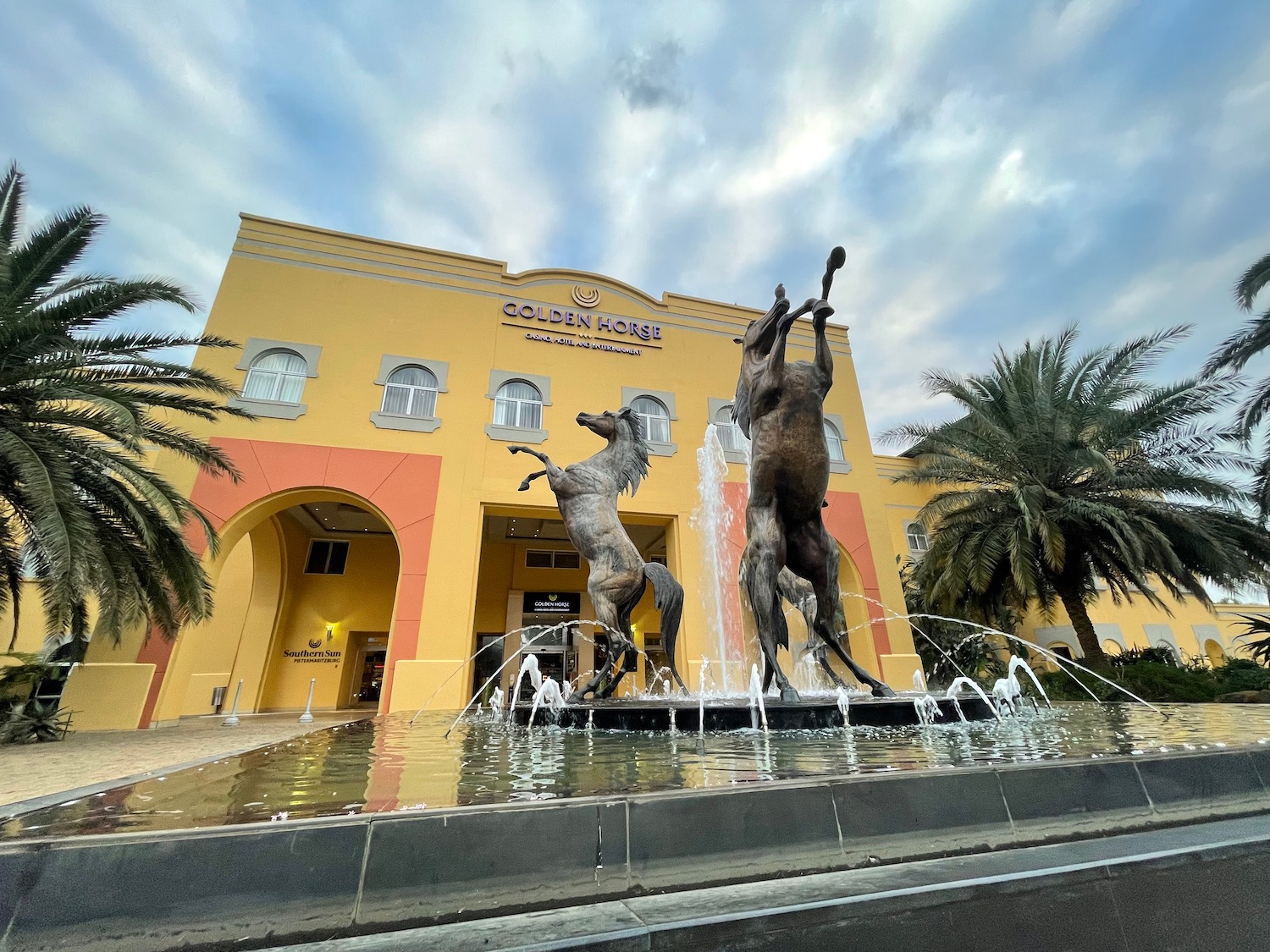 a statue of horses in a fountain in front of a building