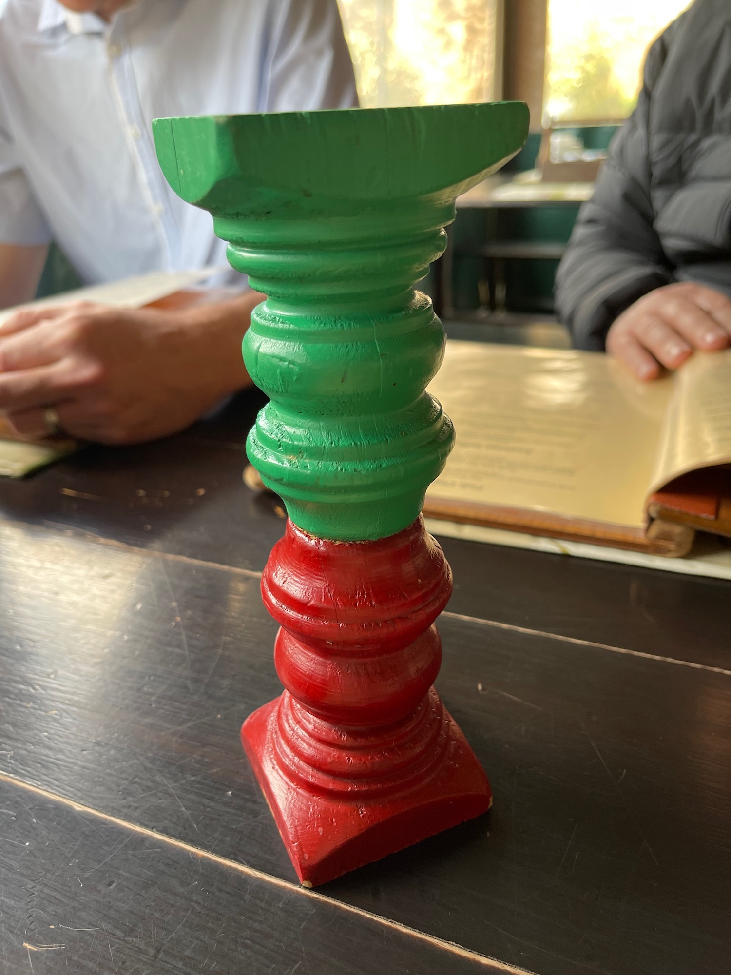 a green and red candle holder on a table