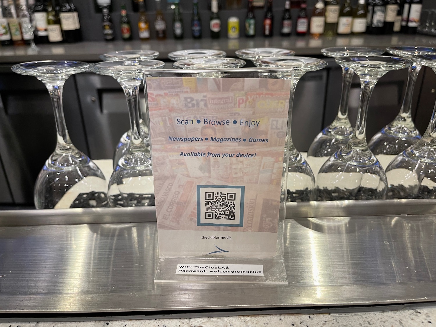 a bar with wine glasses and a sign