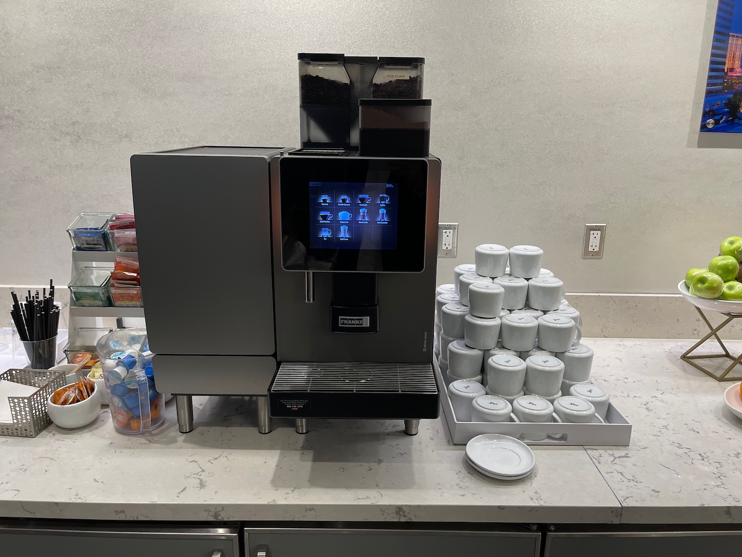 a machine with a screen and a tray of cups