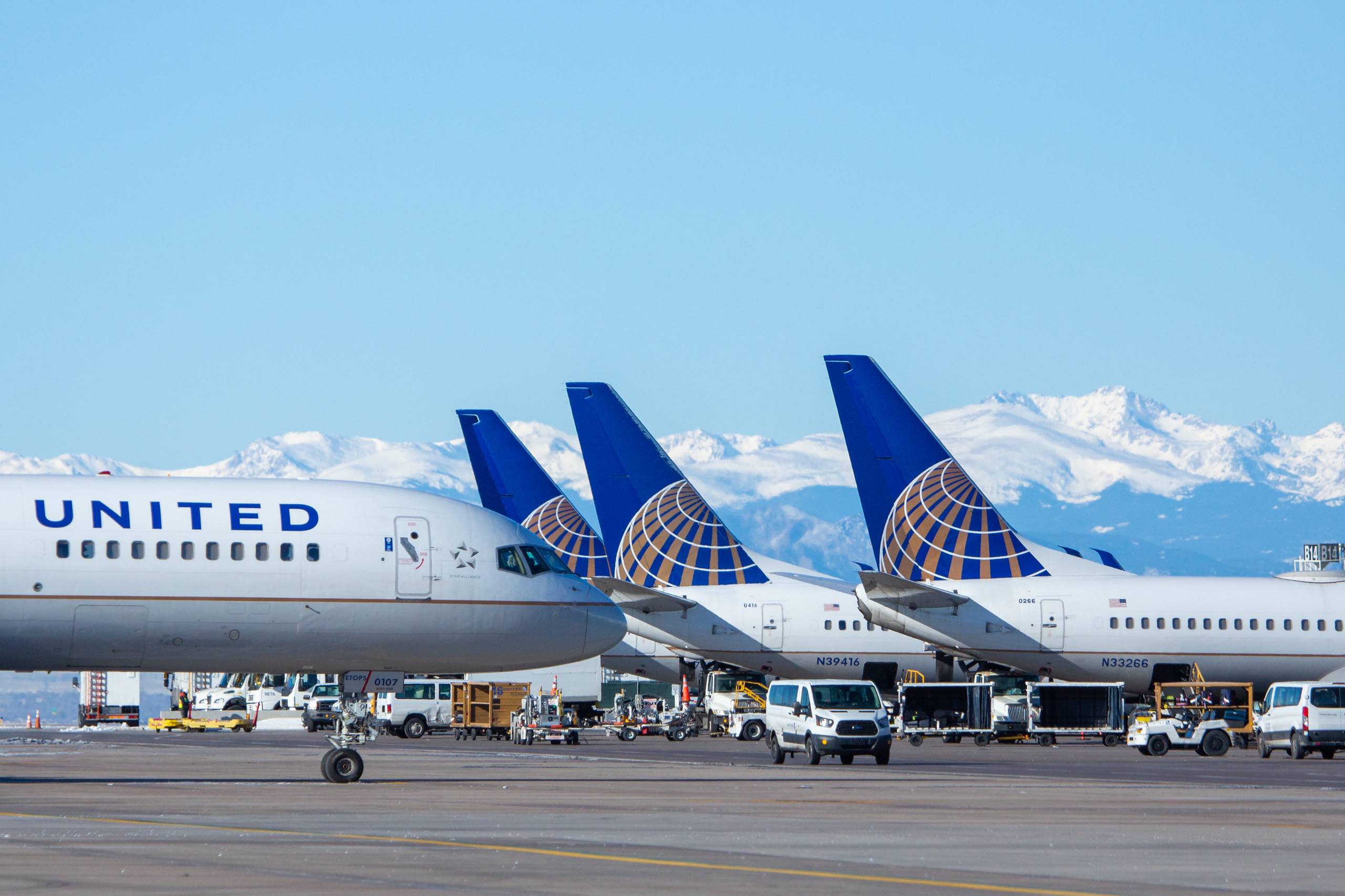 airplanes parked on a runway with mountains in the background
