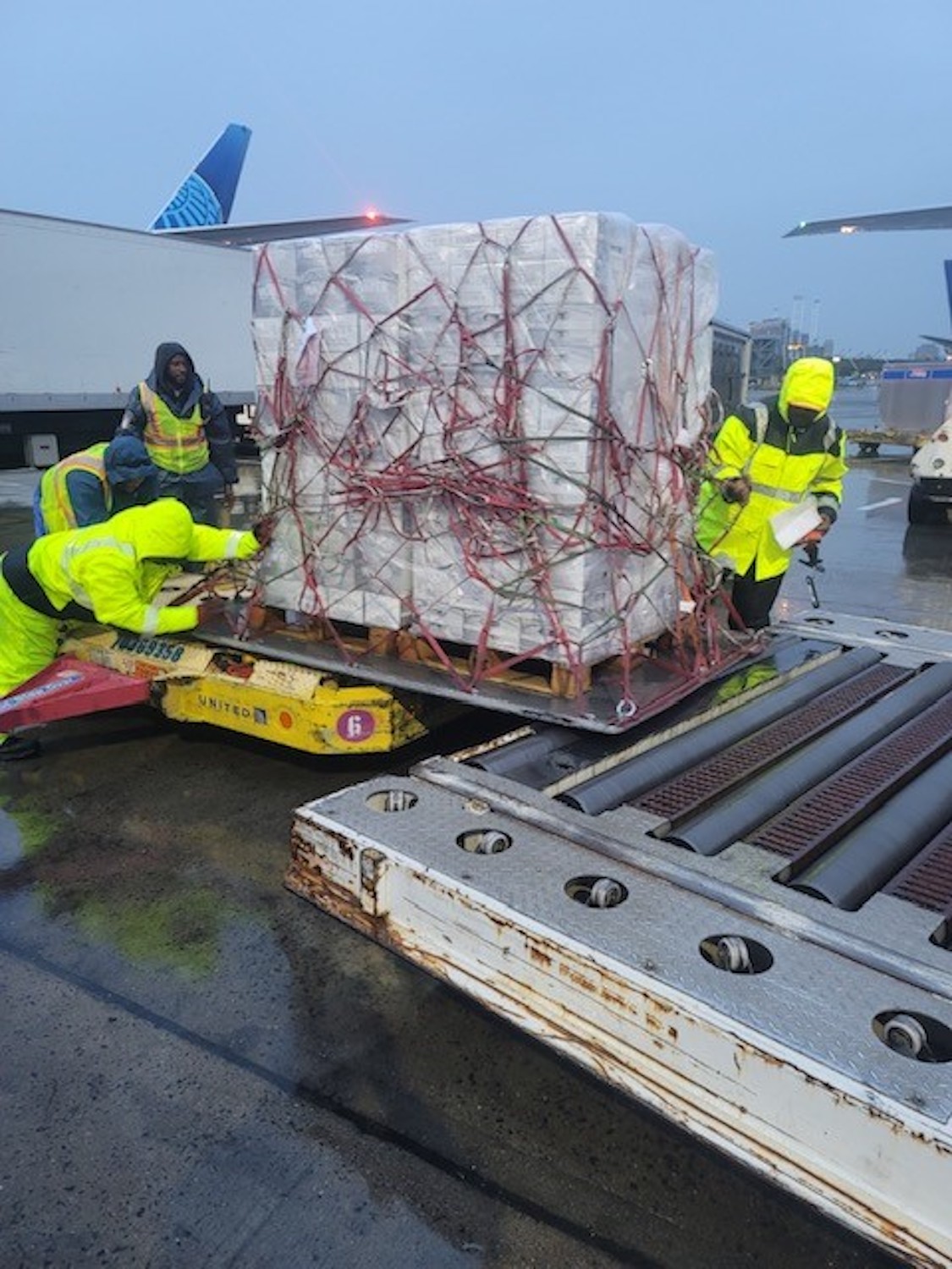 a group of men loading cargo on a truck