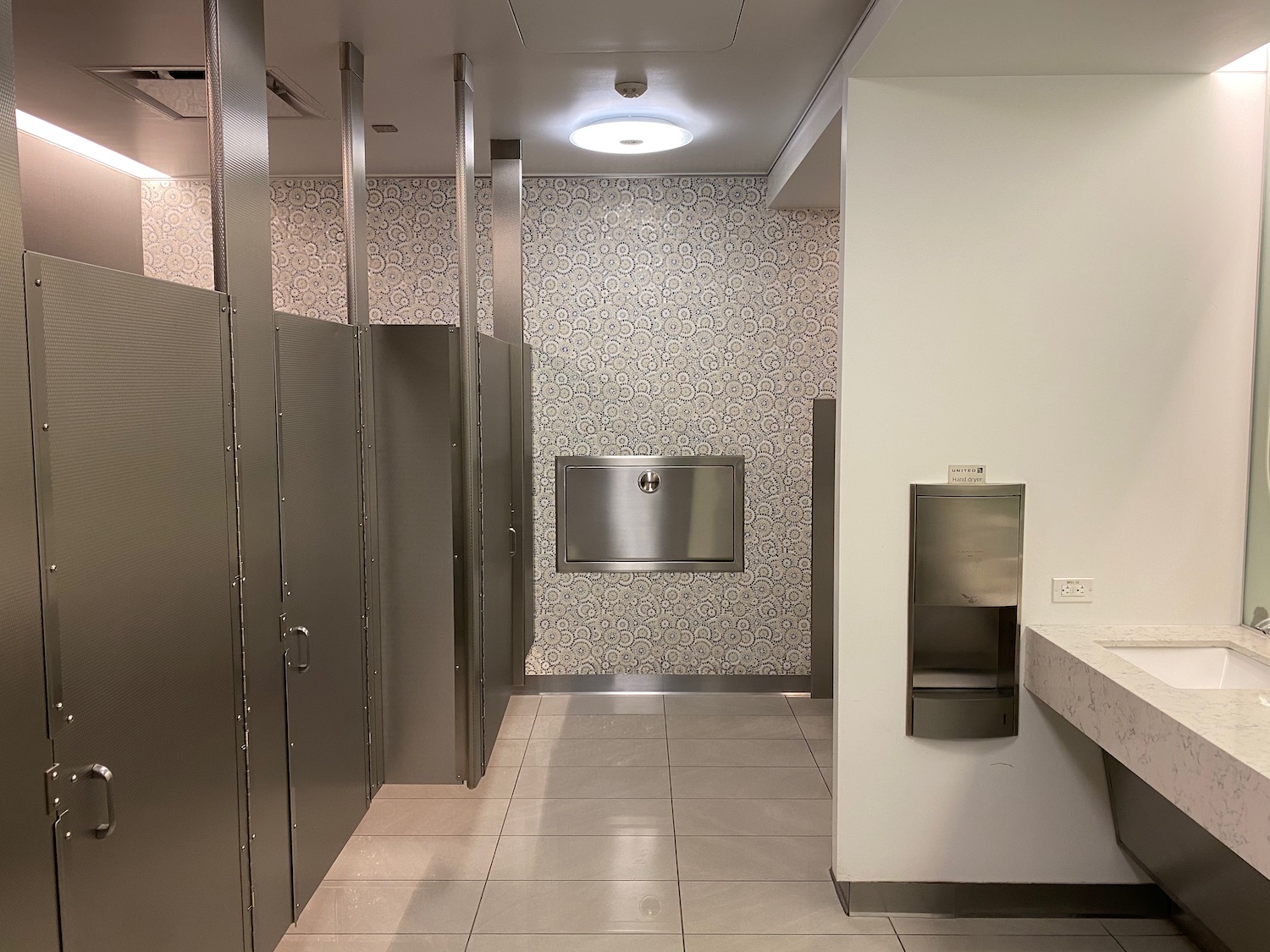 a bathroom with a wall and metal doors