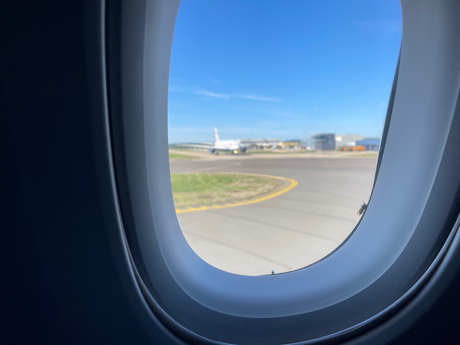 an airplane window with a plane in the background