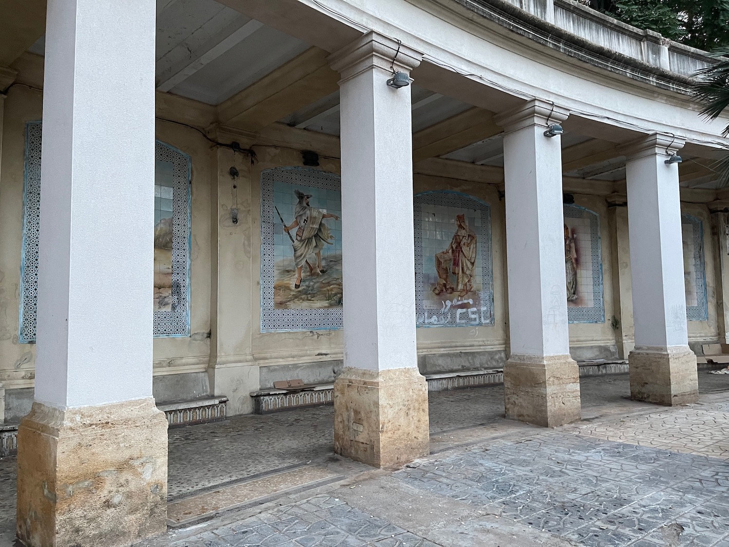 a building with columns and paintings on it
