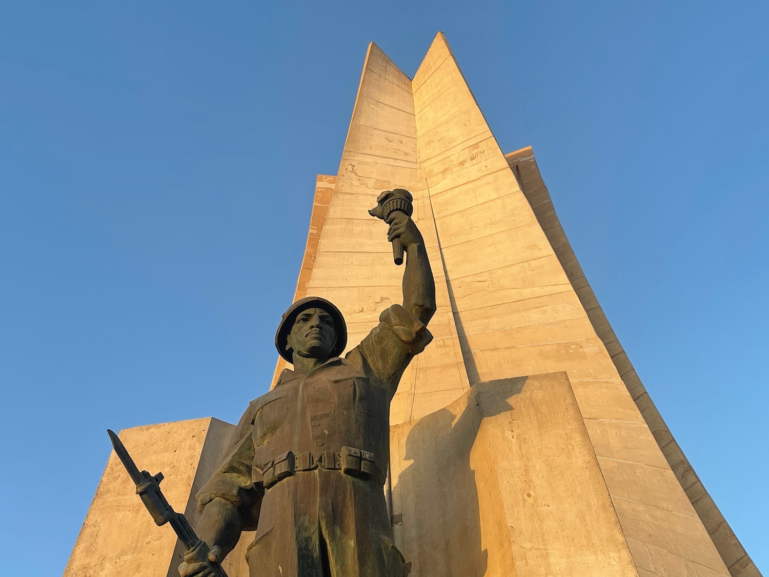 a statue of a man holding a torch and a large tower