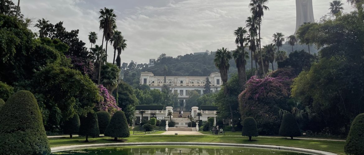 a large circular pool with trees and a building in the background