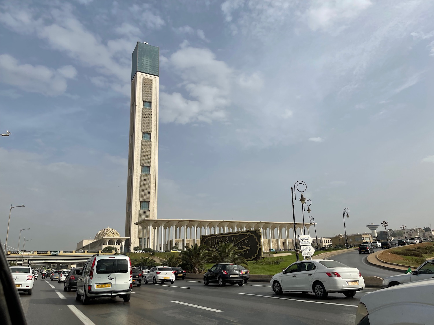 a tall tower with columns and columns on a road with cars