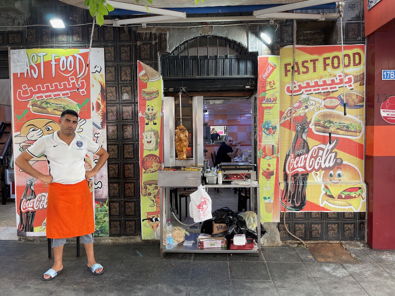 a man standing in front of a food stand