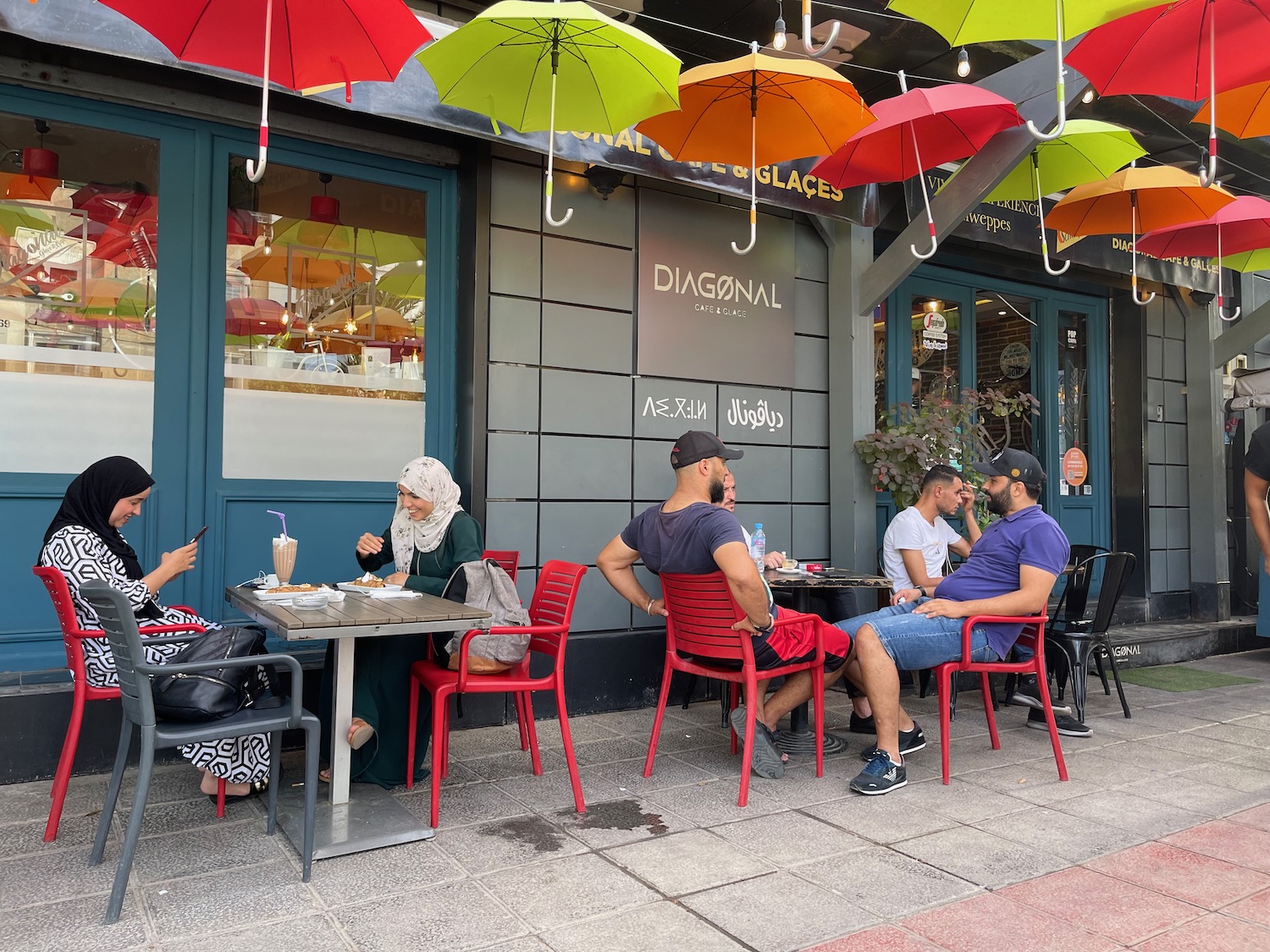 a group of people sitting at a table outside a store