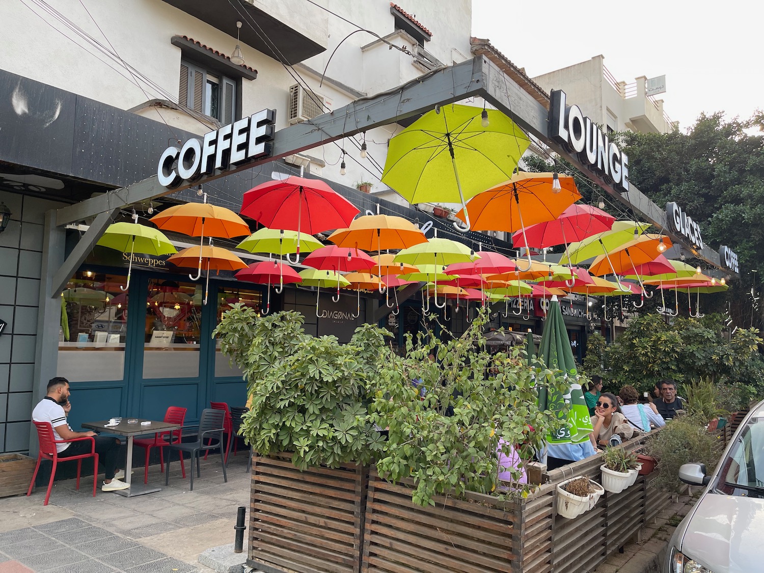 a group of people sitting outside a coffee shop