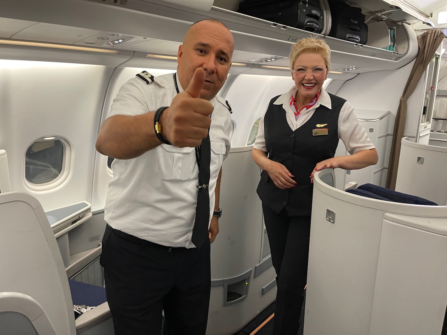 a man and woman in uniform standing in an airplane