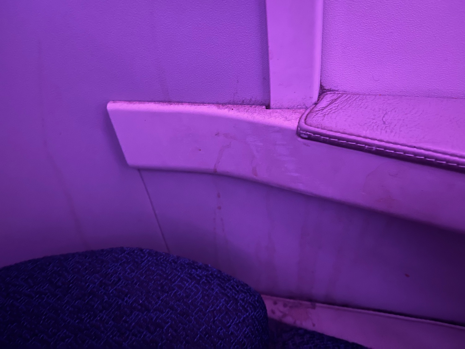 a purple wall with a seat and arm rest