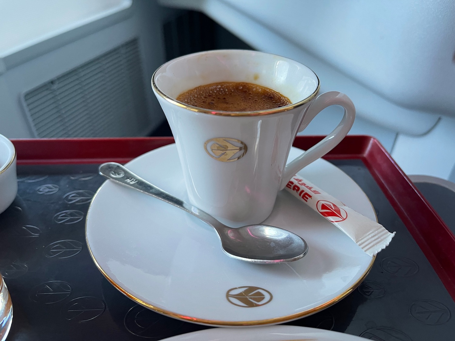 a cup of coffee on a plate with spoon